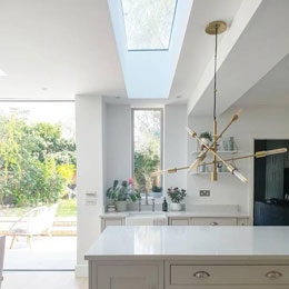 Bright white kitchen with rooflights, window and door